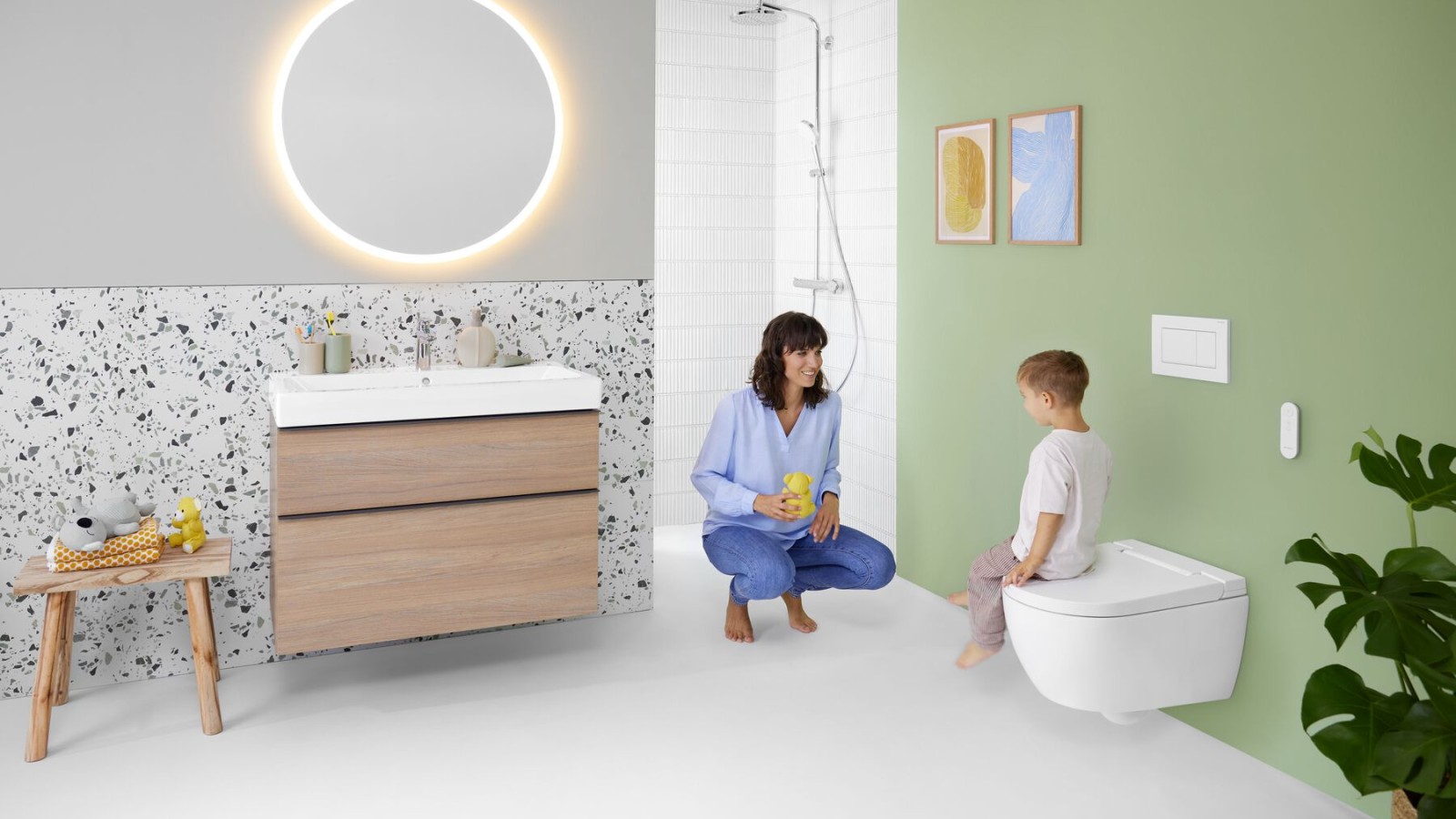 Naine ja laps värvilises vannitoas Geberit Optioni peegli ja Geberit AquaClean Albaga Naine ja laps värvilises vannitoas Geberit Optioni peegli ja Geberit AquaClean Albaga
