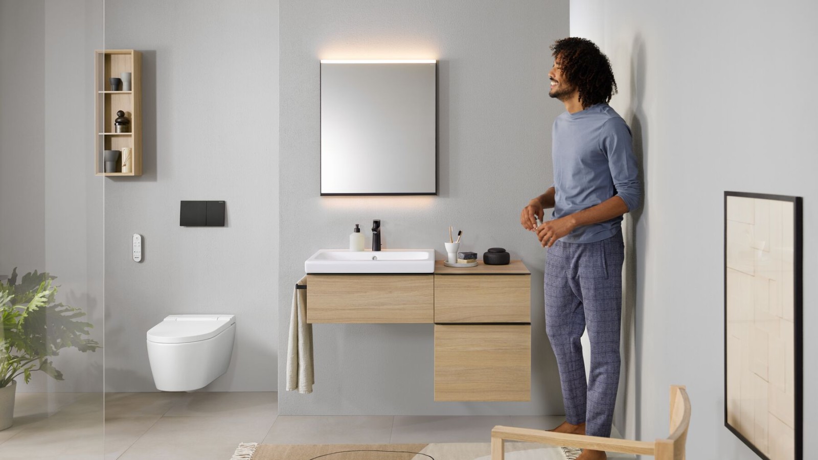 Mees seisab AquaClean Sela dušš-WC-ga vannitoas Mees seisab AquaClean Sela dušš-WC-ga vannitoas