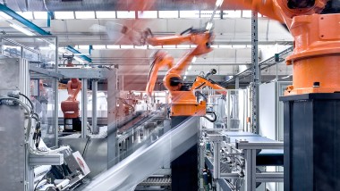 Roboti käed ettevõtte Geberit varjatud loputuskastide tootmissaali konveierlindil (© Geberit)